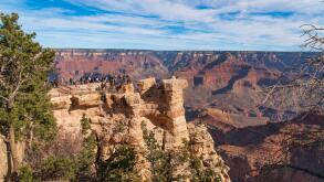 Grand Canyon national park, Arizona. Tourists admiring the panoramic view from one of the view points on the south rim, in November, bright light