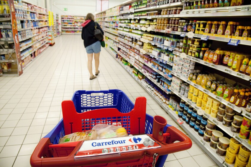 A woman shopping for food in the aisle of a Carrefour French supermarket, France Europe