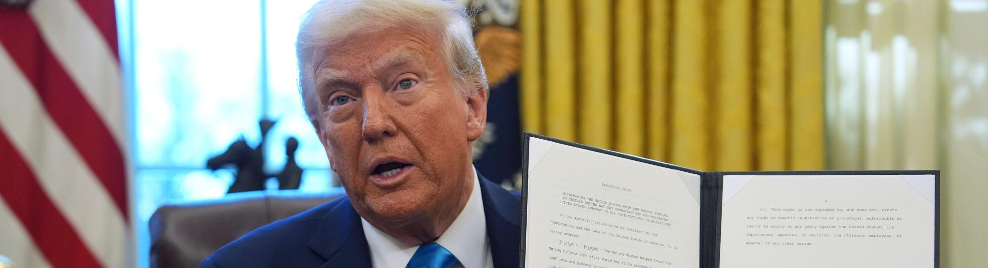 President Donald Trump holds an executive order regarding withdrawing from the United Nationals Human Rights Council in the Oval Office of the White House, Tuesday, Feb. 4, 2025, in Washington. (AP Photo/Evan Vucci)
