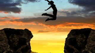 Silhouette the girl jumping over the gap at sunset-adobe-2022