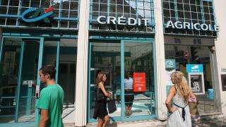 People walk outside a branch of Credit Agricole Bank, in Nice, southeastern France, Wednesday, Sept. 14, 2011. Moody's on Wednesday downgraded the credit ratings of French banks Societe Generale and Credit Agricole following a period of huge volatility in