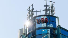 The sun glares off of a UBS Bank logo atop their Canada office in downtown Toronto; UBS is a Swiss global banking company.