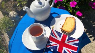 A small table set for tea for one with cake and the Union Jack