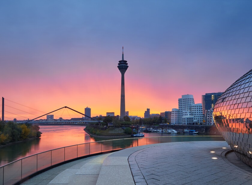 Rainy sunrise in the city of Dusseldorf in Germany. The urban landscape of the city of Düsseldorf. View of the Rheinkniebrücke bridge and the Media Harbor during the golden hour