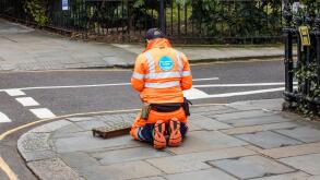 Thames Water employee at work in bright orange overalls in Kensington, London