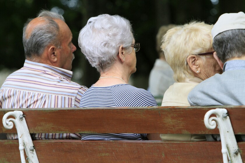 Elderly back sitting on a bench.
