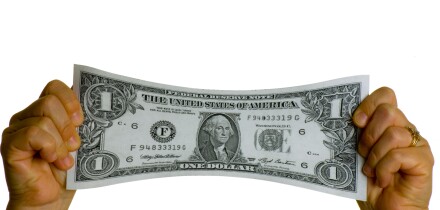 dollar bill USA stretched between two hands. Image shot 2007. Exact date unknown.