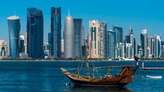 Dhow traditional sailing vessel with the financial area skyline behind, Doha, Qatar