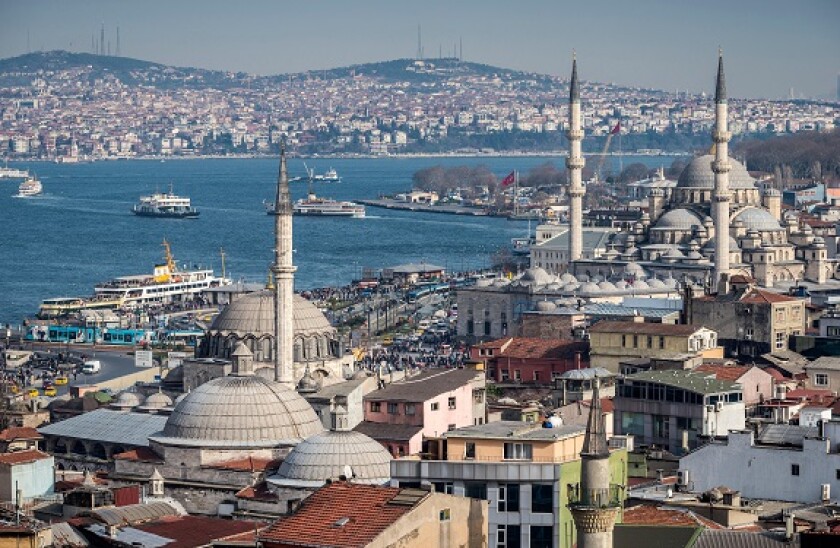 Istanbul skyline, the Bosphorus, ferries sailing towards the Aisian side, Rustem Pasha and Yeni mosques at Eminonou in foregroun