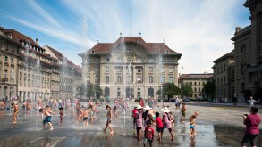 Children playing in the fountains in front of Swiss National Bank in Bern.