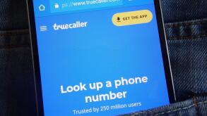 Truecaller website displayed on smartphone hidden in jeans pocket