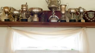 Trophies on a shelf above a list of honorary members plaque in the interior of the club house at the Mauchline lawn bowling green in Mauchline; Ayrshi