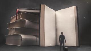 Abstract vision of a businessman standing in front of a huge book with blank pages