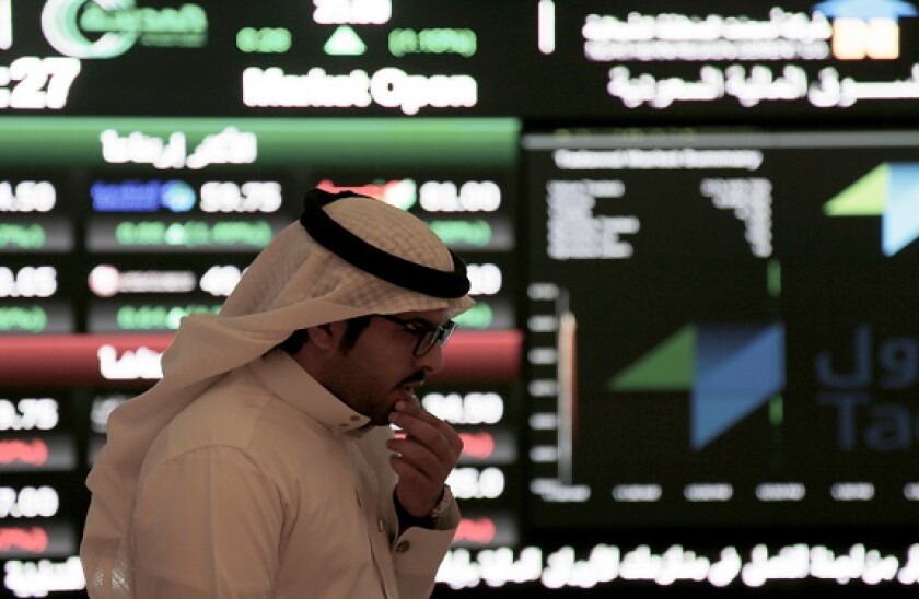A Saudi man walks at the Tadawul Saudi Stock Exchange, in Riyadh, Saudi Arabia, Monday, June 15, 2015.