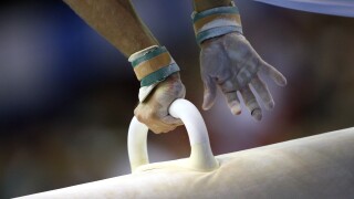 male gymnast competes on pommel horse at a gymnastics competition
