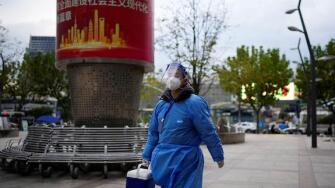 A worker in protective suit walks, as coronavirus disease (COVID-19) outbreaks continue in Shanghai, China, December 5, 2022. REUTERS/Aly Song