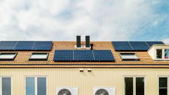 Row of new Dutch houses with solar panels and air-source heat pumps