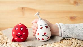 Close up view of girl child hand squeezing white homemade stress ball, made with flour and balloon. At home indoors.