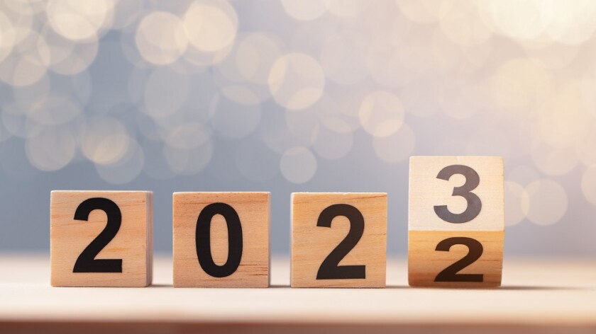 Cube turns from 2022 to 2023 on wooden table