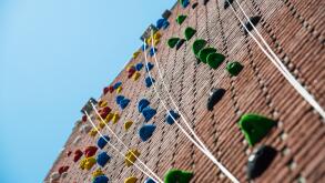 a climbing wall with ropes and blue sky