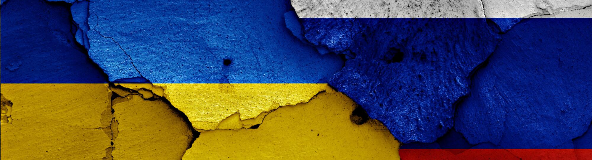 flags of Ukraine and Russia painted on cracked wall