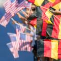 Spectators waving with flags of Germany and USA in front of a blue tartan track. Focus is on the german flags in the foreground