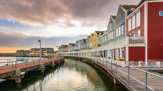 Dutch, modern, colorful vinex architecture style houses at waterside during dramatic and clouded sunset. Houten, Utrecht.