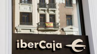A Spanish flag hanging on a balcony is reflected in the glass of Ibercaja bank branch in Madrid, Spain, February 1, 2022. REUTERS/Juan Medina
