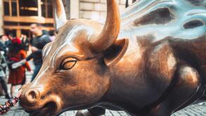 Wall Street charging bull statue in New York City with people