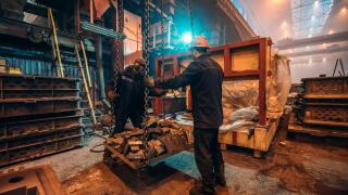 Heavy industry workers in steel mill foundry workshop interior, safety at work and teamwork in metalwork industry.