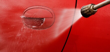 Cleaning the car with a pressure washer at jet wash