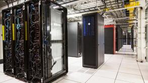 Racks of servers aligned in rows in a large computer server farm.