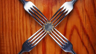Four forks fighting over one euro coin , financial crisis competition ,wood background