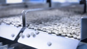 Close up of tablets in packing machine in pharmaceutical factory