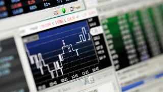 Close-up of stock market values on LCD screen.