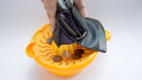 Budget Squeeze - Every last penny being squeezed out of a purse.