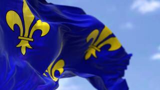 The flag of Ile de France region waving in the wind on a clear day. Ile de France is the most populous of the eighteen regions of France