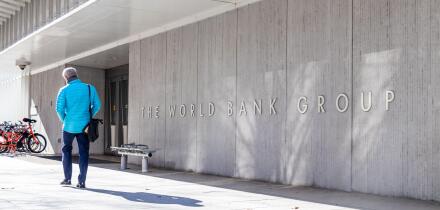 Man walks by a sign for The World Bank Group at their global headquarters in Washington, D.C.