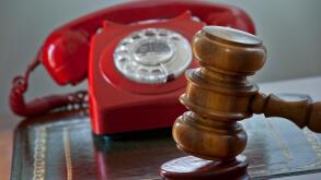 Traditional auction house concept with retro red telephone hot line bids and auctioneers gavel hammer on podium auction desk