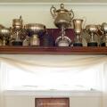 Trophies on a shelf above a list of honorary members plaque in the interior of the club house at the Mauchline lawn bowling green in Mauchline; Ayrshi