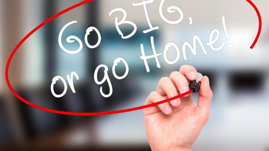 Man Hand writing Go Big or Go Home with black marker on visual screen. Isolated on office. Business, technology, internet concept. Stock Image