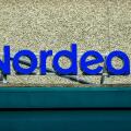 A prominent blue sign displays the name of the bank, Nordea, on the exterior of a well-maintained building, emphasizing its modern design and accessib