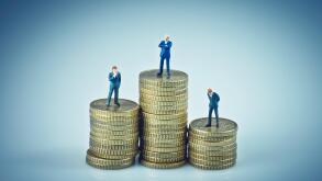 Financial concept. Business people standing on coins piles. Macro photo