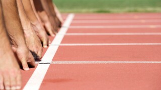 Runners crouched at starting line, cropped