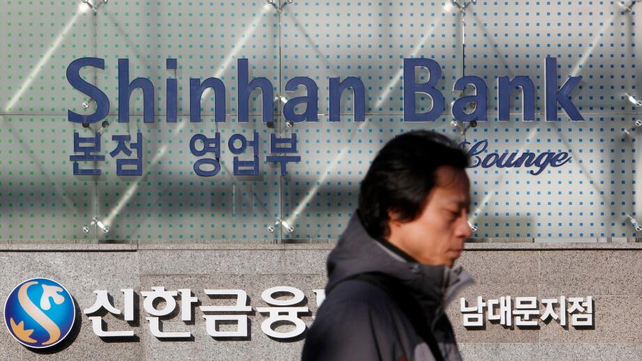 A man walks past the headquarters of Shinhan Bank in Seoul February 4, 2010. Shinhan Financial Group, South Korea's largest financial services firm by market value, posted a 10 percent fall in quarterly profit on Thursday, due to additional costs to cover