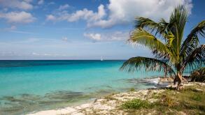 Calm sea and beach with a boat in the distance, South Bimini, Bahamas. The Bahamas National Shark Sanctuary, West Atlantic Ocean.