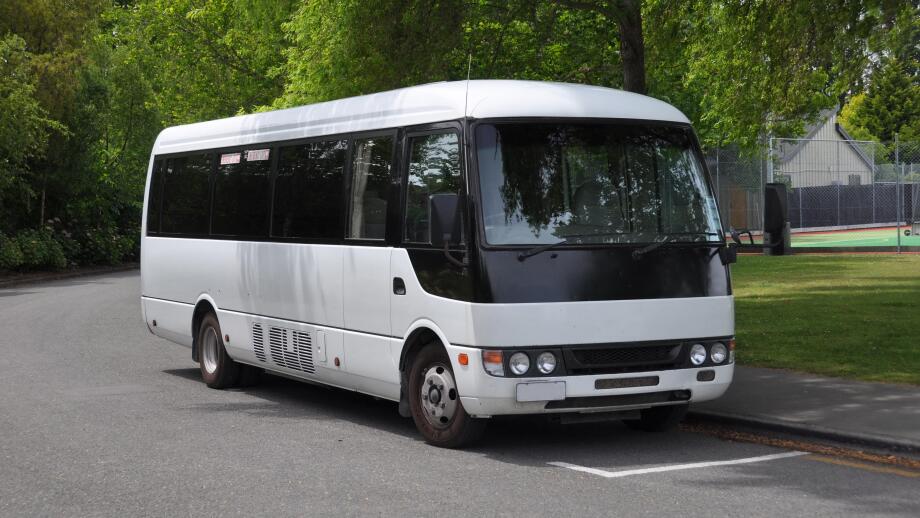 A small white tour coach, bus or mini-van used to transport passengers and tourists. Typically used for small group tours of around 21 passengers.