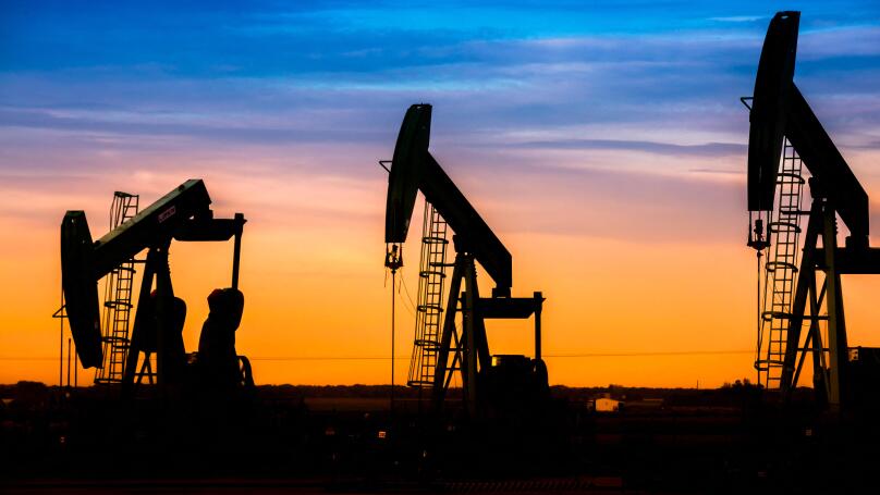 Silhouette of Oil pumps at oil field with nice sunset sky background