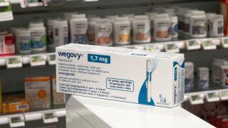 Packaging box of Wegovy (semaglutide) injectable prescription medication, weight-loss drug from Novo Nordisk AS. Pharmacy shop shelves in background.