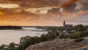 A dramatic colorful sunset in Naantali, Finland with the church and archipelago, sea and Moomin island